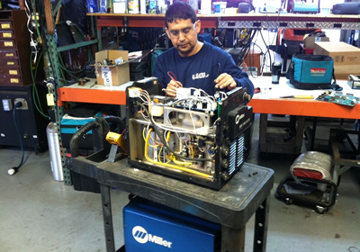 Neyl Montesano repairing Miller equipment at R.J. Kates